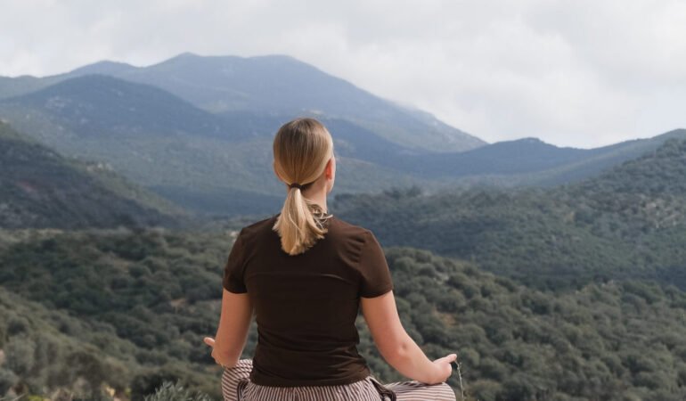woman meditates  mountain, embracing serenity and mindfulness. A peaceful retreat in nature, self-care, wellness, and inner balance. A moment of stillness, reflection, and spiritual awakening